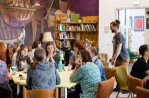 Insgesamt sind sechs Bilder zu sehen. Die Bilder zeigen mehrere Szenen aus dem Erzählcafé Görlitz. Mehrere Menschen unterschiedlichen Alters sitzen an Tischen, in entspannter Atmosphäre, vertieft in Gespräche.